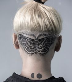 a woman with a butterfly tattoo on her neck and behind the head is a black dot