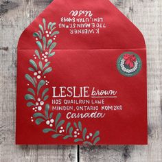 a red envelope with the words leilie brown on it and an ornament