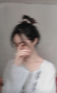 a blurry photo of a woman holding her hand to her face