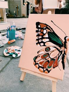 an easel with a butterfly painted on it