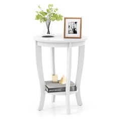 a small white table with a vase and some books on it's side shelf