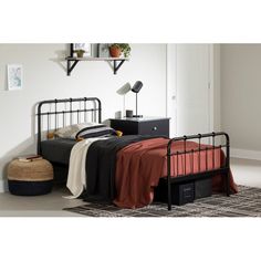 a black metal bed frame with red sheets