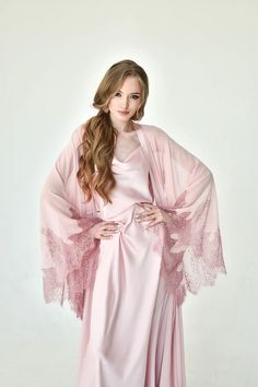 Airy and fairy as it gets robe and nightgown ensemble in pale rose. The robe reaches the floor and features bell sleeves decorated with lace. The nightgown with draped décolleté is of easily regulated length, thanks to its adjustable shoulder straps Silk Robe Long, Seductive Style, Pink Nightgown, Luxury Robes, Nightgown Sets, Pyjama Satin, Peignoir Sets, Vilnius Lithuania, Black Kimono