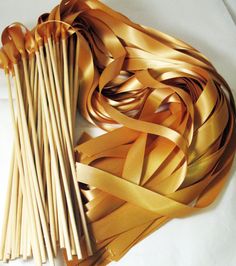 a bunch of sticks that are next to each other on a white surface with gold ribbons