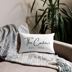 a pillow that says the caterer's estt, 2012 on it sitting on a couch next to a potted plant