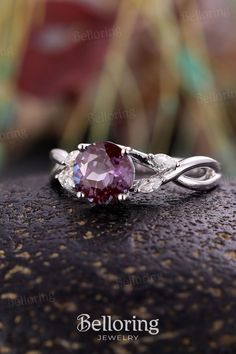 a close up view of a ring with a pink stone