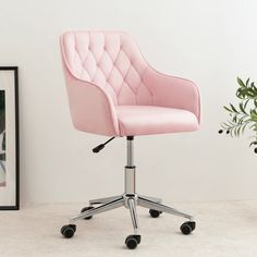 a pink office chair sitting on top of a white floor next to a potted plant