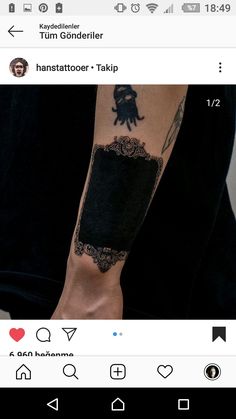 a person with a tattoo on their arm and the other hand is holding a black object