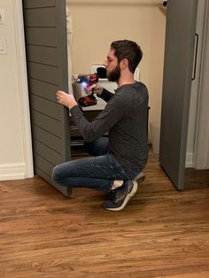 a man sitting on the floor in front of an open door and holding a camera