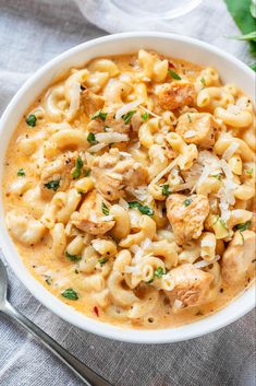 a white bowl filled with macaroni and cheese on top of a blue cloth