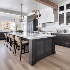 a large kitchen with an island in the middle and chairs around it, along with marble counter tops