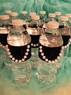 six plastic water bottles with black and white beads on the lids, lined up in a row