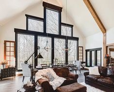 a living room filled with furniture and large windows