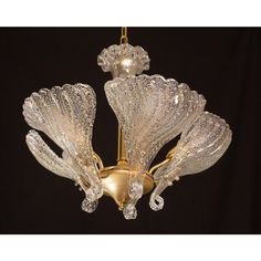 a chandelier hanging from the ceiling with glass petals on it's arms