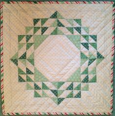 a green and white quilted wall hanging