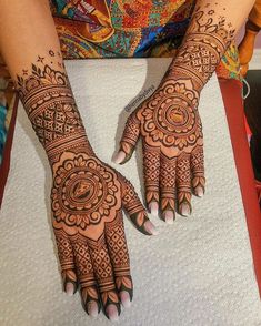 two hands with henna tattoos on them