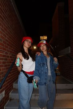 two young women are standing on the steps outside at night with their arms around each other