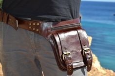 Dark brown leather hip belt with brass hardware This beautiful BROWN leather utility belt with two antique brass buckle  hardware  is edgy and goes great with every style. The soft leather conforms to your waist. This utility belt is handmade with the best quality on the market. This holster type storage belt features  in the front one snap closure storage pouches, one zippered and one rear side zippered compartment. This belt stores almost any sized phone on the market. Please verify with the m Steampunk Leather Bag With Belt Loops, Leather Hip Pouch, Psytrance Clothing, Leather Pocket Belt, Belt Store, Leather Utility Belt, Hip Pouch, Medieval Belt, Designer Leather Bags