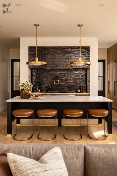 a kitchen island with four stools in front of it