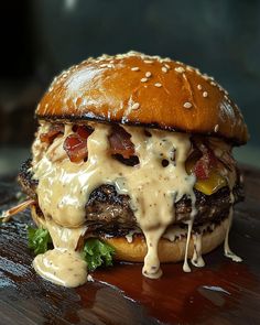 a cheeseburger with bacon, lettuce and other toppings on a wooden table