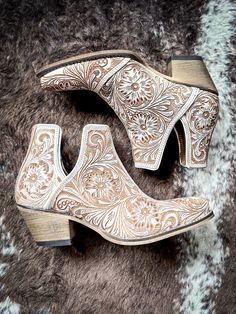 Step into the epitome of Southwestern flair with these Western leather booties, meticulously hand-tooled to highlight a stunning blend of rich white and chocolate hues. Featuring classic cowboy heels and convenient side slits, they blend traditional craftsmanship with modern ease. The intricate design, showcasing a pattern of desert blossoms, adds a distinctive touch of elegance. Ideal for transforming any ensemble, these tooled boots exude statement-making style with every step. 2" slanted heel Hay Bag, Classic Cowboy, Pick Your Poison, Wrap Boots, Silver Jewelry Box, Horse Boots, Hand Tooled Leather, Western Leather