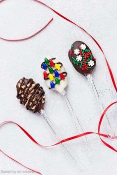 three chocolate covered candy lollipops with decorations on them