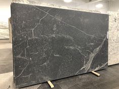 two black and white marble slabs sitting on top of each other in a room with lights