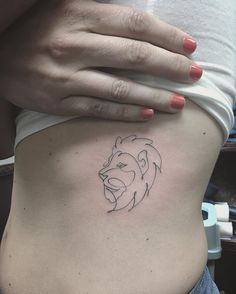 a woman's stomach with a small tattoo of a lion on the lower side