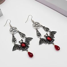 These earrings feature red vampire bat wings with a bangle and have a pentacle design. The pentacle is a symbol of protection and balance. They are mighty and can help you connect with your dark side. Wearing these can boost your confidence and make you feel protected. It's the perfect accessory for you and will surely add magick to any outfit. Specification： Material: AlloyTreatment process: electroplatingSize: 3.07"x1.81" (7.8x4.6cm)Package Size: 80 x 80 x 30 mm Gothic Red Jewelry For Halloween, Red Gothic Jewelry For Halloween, Adjustable Red Gothic Jewelry, Gothic Dangle Halloween Jewelry, Gothic Dangle Jewelry For Halloween, Vampire Style Metal Earrings For Halloween, Halloween Vampire Metal Earrings, Red Nickel-free Jewelry For Halloween, Nickel-free Red Halloween Jewelry