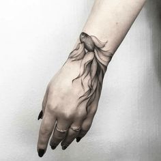 a woman's hand with a tattoo on it and water flowing down the arm