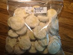 a bag filled with white cookies sitting on top of a wooden table