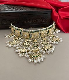 A glamorous bridal jewelry set for the contemporary bride of today! Beautiful meenakari kundan necklace set embellished with kundan stones and pearls detailing. The set includes a princess necklace, a tika and a pair of beautiful long earrings.  Details: Princess Necklace: Upper Choker Width-1.25 Inches Lower Choker Width-4 Inches Earrings Length-4.5 Inches Weight of Each Earring-21 gma Tika Length-7 Inches All products are manufactured using traditional skills from our rich heritage of crafts. Temple Style Kundan Necklace For Reception, Kundan Meenakari Jewelry For Reception, Kundan Necklace With Pallu For Weddings, Kundan Necklace With Cutdana For Wedding, Kundan Necklace With Zari Work For Wedding, Kundan Temple Jewelry Bridal Necklace For Reception, Chandbali Kundan Necklace For Eid Reception, Kundan Bridal Sets With Cutdana For Reception, Eid Reception Kundan Necklace With Tilla