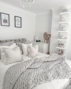 a bed with white pillows and blankets on top of it