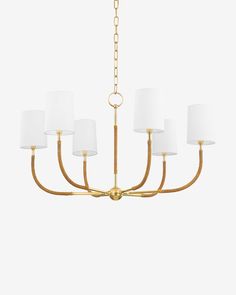 a brass chandelier with white shades