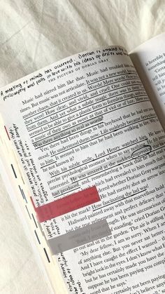 an open book with some type of writing on it's page and a red marker in the middle