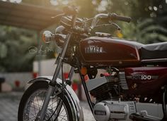 a yamaha motorcycle parked in front of a building with the sun shining down on it