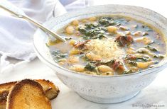 a bowl of soup with bread on the side