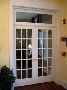 a white double door with glass panels in a room