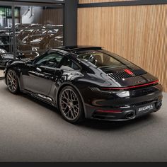 a black sports car parked in front of a building