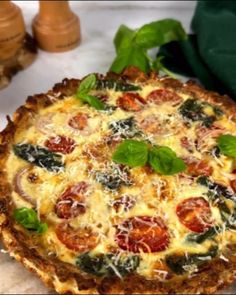 a pizza sitting on top of a table covered in cheese and veggie toppings