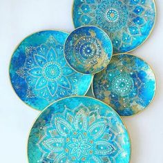 four blue and gold plates with designs on them