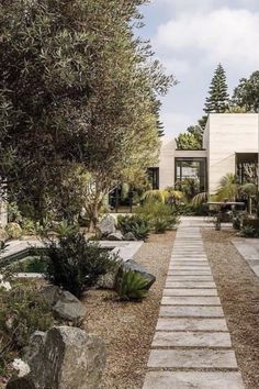 a stone path leading to a house surrounded by trees