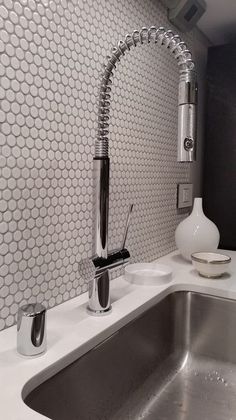 a kitchen sink with a faucet and soap dispenser next to it