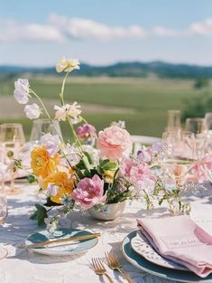 the table is set with flowers and wine glasses