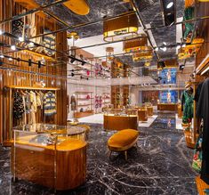 the inside of a clothing store with marble flooring and wooden shelves filled with clothes