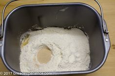 a metal pan filled with flour on top of a wooden table