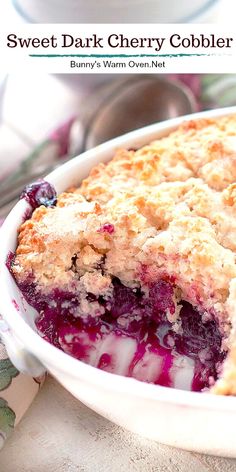 a close up of a pie in a pan on a table with the words, sweet dark cherry cobbler