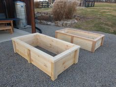 two wooden planters sitting on top of gravel