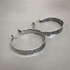 "Beautiful rustic hammered sterling silver hoops to dress up any outfit - they're perfect to go with just about anything! They're light and airy, and they'll be your new go-to earrings. These earrings are made to order, so please allow me 2-3 weeks to make them just for you! The Details: - 1-3/4\" in diameter - ear wire fastens into the back of the hoop for security - lightweight 24g sterling silver" Everyday Sterling Silver Hammered Hoop Earrings, Silver Hammered Hoop Earrings For Everyday, Everyday Silver Hammered Hoop Earrings, Artisan Silver Hammered Hoop Earrings, Silver Hammered Artisan Hoop Earrings, Hammered Artisan Hoop Earrings For Everyday, Artisan Hammered Round Hoop Earrings, Artisan Hammered Hoop Earrings For Everyday, Everyday Artisan Hammered Hoop Earrings