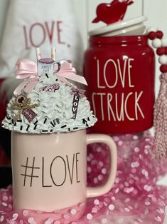 a pink coffee mug with white and black flowers in it that says love on the inside